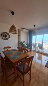 a dining room with a table and chairs and a balcony at Vista al Mar in Piles