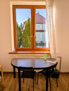 a table and chairs in a room with a window at Hostel Kalinowskiego in Żary