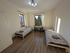 a room with two beds and a table in it at Hostel Kalinowskiego in Żary +16 photos
