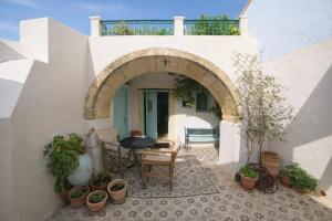 an archway in a white building with potted plants at Incavo in Potamós