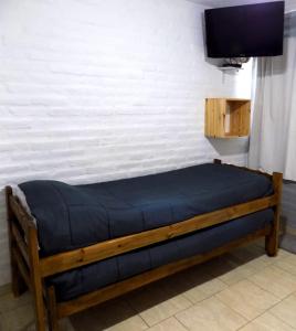 a bed in a room with a tv on a wall at HoltFor in Potrero de los Funes