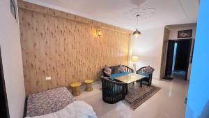 a living room with a table and a couch at Premium 2BHK near Kainchi Dham in Bhowāli