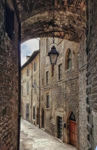 an alley in an old stone building with a lamp at Residenza Via Felicchi 10 in Gubbio