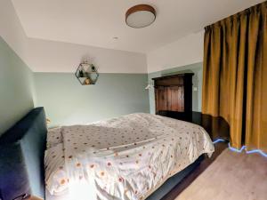 a bedroom with a bed with a white comforter at Aska Logies vakantiewoning in As +20 photos