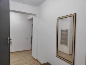 a mirror on a wall next to a hallway at Voievozilor Residence in Constanţa