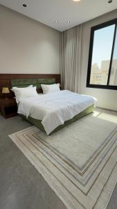 a bedroom with a large bed and a large window at وصول ذاتي Alsumo-apartment in Jeddah