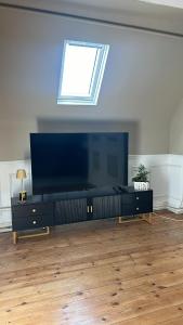 a living room with a large flat screen tv at Studio avec vue piscine in Missy-sur-Aisne