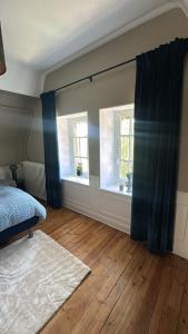 a bedroom with a bed and two windows at Studio avec vue piscine in Missy-sur-Aisne