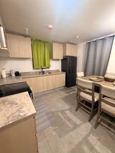 a large kitchen with a table and a refrigerator at Royal's 2 Bedroom suite in Kingston