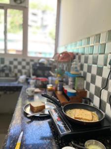 a stove top with a pan of bread and toast at Premium 2BHK near Kainchi Dham in Bhowāli