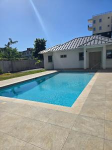 a swimming pool in front of a building at Royal's 2 Bedroom suite in Kingston