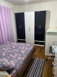 a bedroom with black and white cabinets and a bed at Sítio Meu Cantinho in Benedito Novo