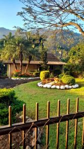 a fence in front of a house with a garden at Sítio Meu Cantinho in Benedito Novo