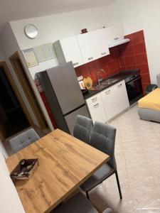 a kitchen with a wooden table and a refrigerator at Apartman 6 Majba in Zaglavice