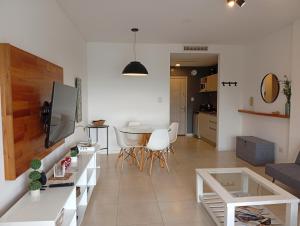 a white living room with a table and chairs at Bahía Grande Nordelta - con Cochera in Benavídez