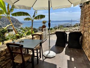 a table and chairs on a patio with an umbrella at HillSide Apartments - 02 in Agia Galini
