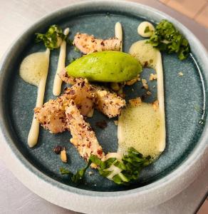 a blue plate with food on a table at auberge des trois ami-es in Vinezac