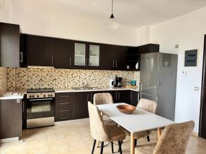 a kitchen with a white table and chairs and a stove at HillSide Apartments - 02 in Agia Galini +9 photos