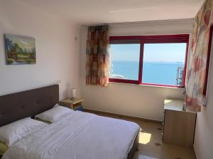 a bedroom with a bed and a large window at Casa del Mar 2-Sea view Vollga, 2BR in Durrës