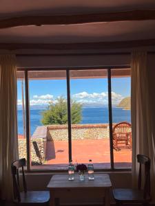 a view of the ocean from a dining room window at Puma Punku Lodge in Isla Chillica +4 photos