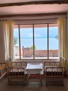 a table and chairs in front of a large window at Puma Punku Lodge in Isla Chillica