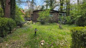 a house in a yard with a parking meter in the grass at Huisje Jan in Hoenderloo