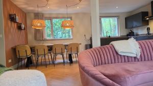 a living room with a couch and a table and chairs at Huisje Jan in Hoenderloo