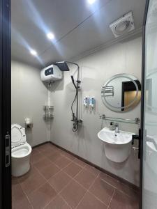 a bathroom with a toilet and a sink and a mirror at Mây Đá Homestay in Loung Co
