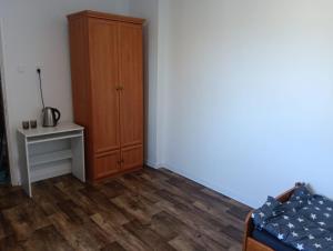 a bedroom with a cabinet and a bed and a table at Noclegi Adam in Radonia