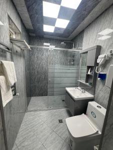a bathroom with a shower and a toilet and a sink at Grotto Resort & Restaurant in Quba +63 photos