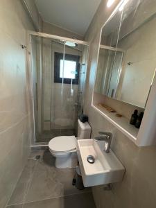 a bathroom with a toilet and a sink and a shower at MareMonti VILLAS in Sidhirodhromikós Stathmós Krioneríou +37 photos