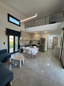a living room with a table and a kitchen at MareMonti VILLAS in Sidhirodhromikós Stathmós Krioneríou