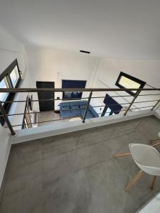 a room with a balcony with blue chairs and a table at MareMonti VILLAS in Sidhirodhromikós Stathmós Krioneríou