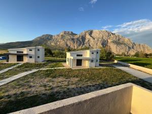two white buildings with a mountain in the background at MareMonti VILLAS in Sidhirodhromikós Stathmós Krioneríou