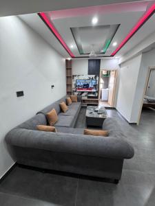 a living room with a large couch and a tv at Hotel White Castle Islamabad in Islamabad