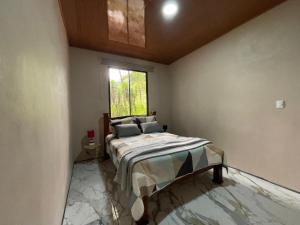 a bedroom with a bed and a window at Althi Mountain House in Naranjito