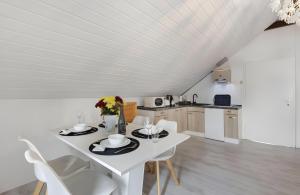 a white dining room with a white table and chairs at Schwarzwaldglück Loft in St. Blasien