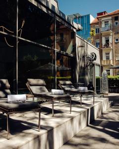a row of chairs sitting in front of a building at Augarten Art Hotel, a Member of Design Hotels in Graz