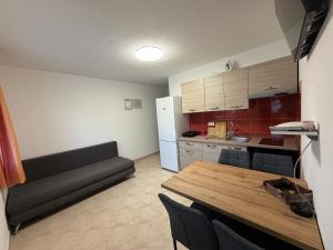 a kitchen with a table and a couch in a room at Apartman 5 Majba in Zaglavice