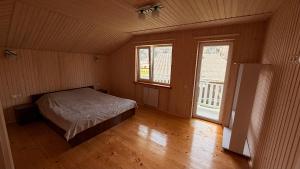 a bedroom with a bed in a room with two windows at Mountain apartments in Usteriki