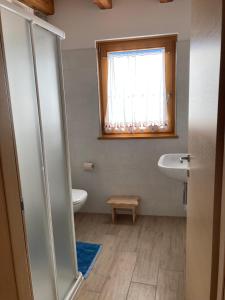 a bathroom with a sink and a toilet and a window at Il moleta affittacamere in Balbido-rango