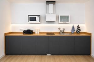a kitchen with a counter with a sink and a microwave at Prime Suites Valencia in Valencia