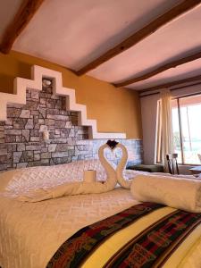 a bedroom with two swans sitting on a bed at Puma Punku Lodge in Isla Chillica