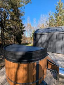 a barrel for a hot tub in a backyard at Leno Tu - Domki przy jeziorze z sauną i banią in Ciemno