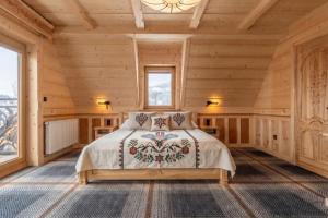 a bedroom in a log cabin with a bed at WHY NOT Myśliwska Exclusive Residence z basenem in Kościelisko