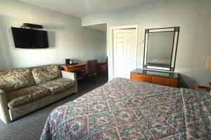a hotel room with a bed and a couch at At 9 Motel Near Freehold I-195 in Howell