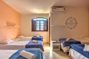 a room with three beds and a window at Pousada Recanto Barra da Tijuca in Rio de Janeiro