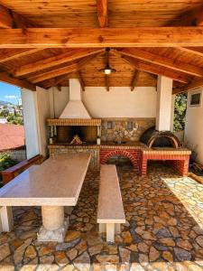 a large patio with a stone fireplace and a picnic table at Vila Bilali in Ksamil