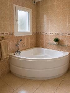 a large white tub in a bathroom with a window at PROVENCE, MAISON SPACIEUSE et CONFORTABLE à coté de SPIROU,NARUTO et , WAVE ISLAND in Monteux