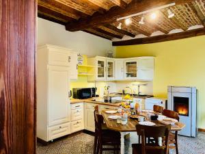 a kitchen with a table and chairs and a kitchen with yellow at La Ferme du Ravet - Gîtes aux Lacs de l'Eau d'Heure in Froid-Chapelle
